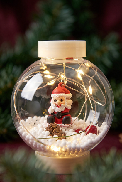Close-up of miniature Santa and snowy details inside a transparent globe