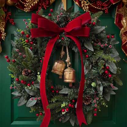 Christmas wreath with crimson bow and two golden bells on an emerald door